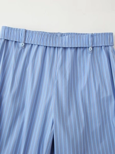 Detail of blue striped pajama pants with elastic waist, belt loops, and buttons