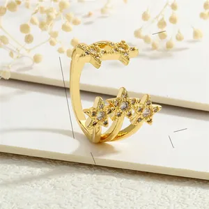 Detailed view of adjustable gold star ring with zircon stones on white card background