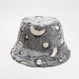 Detail shot of plush grey bucket hat featuring luminous moon and star patterns