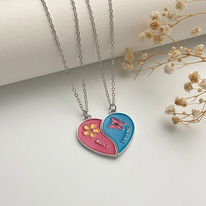 Detail of pink and blue enamel heart pendants with Best Friend engraving and flower patterns