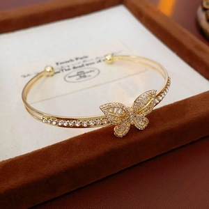 Detail of gold-plated butterfly open bracelet with pavé cubic zirconia on jewelry tray