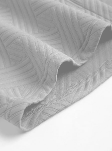 Gros plan du tissu jacquard gris avec texture géométrique et couture d'ensemble homme