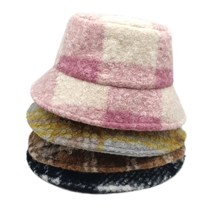 Detail showing stacked plaid teddy fleece bucket hats in various winter colors