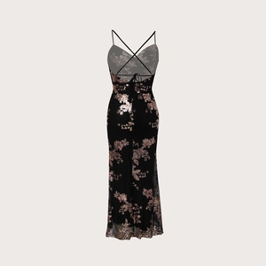 Détail des bretelles croisées d'une robe de soirée noire à paillettes et motifs dorés