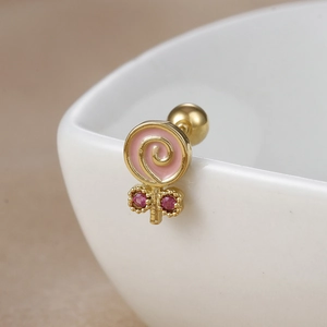Detailed macro view of lollipop stud earring with pink glaze and red zircon accents