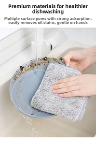 Detail of charcoal fiber cleaning cloth washing oily dishes under water in sink