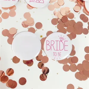 Gros plan des badges Team Bride et Bride to Be blancs avec motifs diamants roses