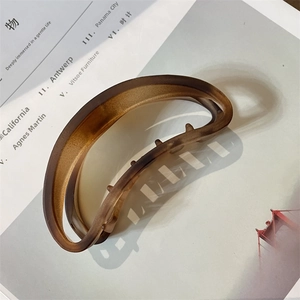 Detail of large matte brown hair claw clip with smooth frosted texture on magazine