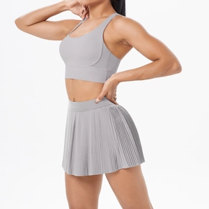 Vue latérale d'un ensemble brassière de sport et jupe de tennis plissée gris clair