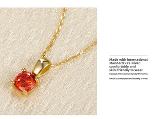 Detailed close-up of 925 sterling silver gold-plated pendant with red zircon inlay