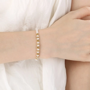 Detail of elegant pearl and gold bead bracelet worn on wrist with floral spacers