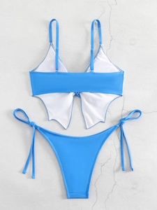 Flat lay of blue two-piece bikini with butterfly wing back detail on a textured background