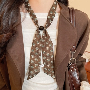 Close-up of floral chiffon scarf necklace with black buckle on vintage blazer outfit
