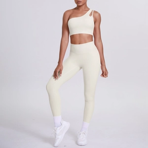 Detail of cream one-shoulder yoga bra and high-waisted leggings set on model