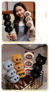 Detail of plush cat toy skewer featuring soft stacked feline heads with a brown handle