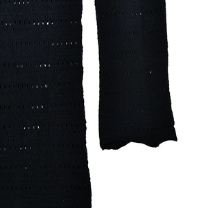 Close-up detail of black hollow-out mesh fabric with textured lace pattern