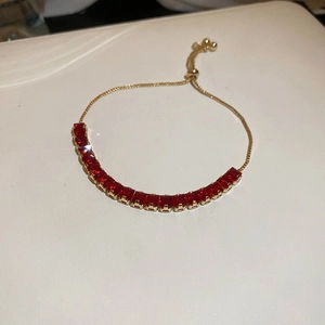 Detail of red square zircon stones on a gold-plated adjustable chain bracelet