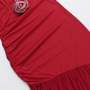Detail of red slim dress featuring ruched fabric and a 3D fabric rose floral decoration