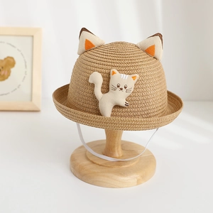 Détail d'un chapeau de paille pour enfant avec oreilles de chat et peluche mignonne