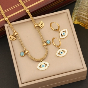 Gold evil eye jewelry set with turquoise beads necklace and earrings on a jewelry box