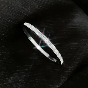 Macro detail of silver titanium steel bracelet featuring full diamond pave setting
