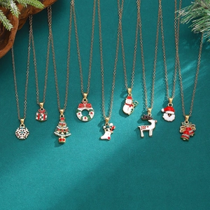Detailed flat lay of Christmas necklaces with enamel snowmen and reindeer charms