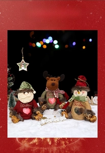Close-up of burlap Christmas gift bags with Santa, reindeer and snowman character designs