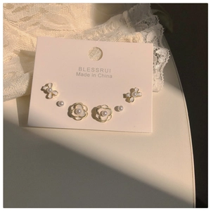 Detailed view of camellia and pearl earring set with elegant gold-plated finish