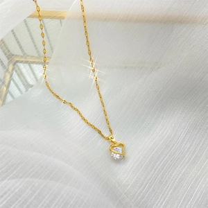 Pendentif cœur doré élégant avec grand zircon sur un fond blanc texturé luxueux