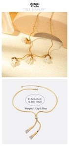 Detail of vintage gold flower chain and snake bone necklace with wheat tassel and rhinestones