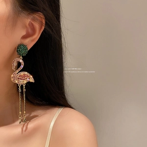 Elegant flamingo tassel earrings with colorful rhinestones and gold chains on model