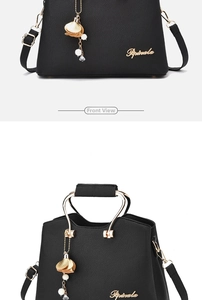 Detail of black lychee grain handbag with gold hardware and floral tassel charm decoration