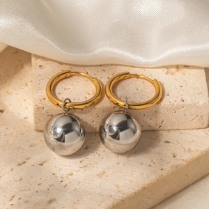 Détail macro de boucles d'oreilles bicolores avec sphères argentées sur pierre naturelle