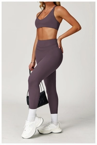 Detail of high-waist yoga pants and V-neck sports bra in matte deep plum fabric