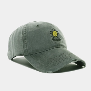 Detail of washed olive baseball cap with sunshine embroidery and distressed brim edge