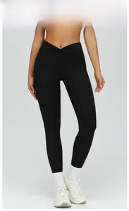 Detail of high-waist V-shaped crossover waistband on black slim-fit yoga pants