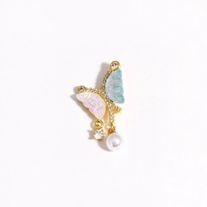 Macro view of butterfly pendant with blue and pink resin, zircon inlay and hanging pearl