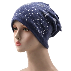 Navy blue knitted beanie with rhinestone star patterns on a display mannequin