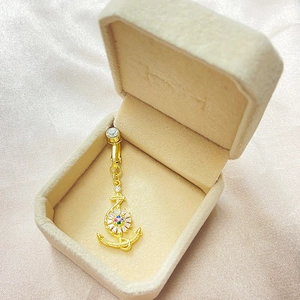 Piercing de nombril ancre dorée avec fleur en zircon dans un coffret à bijoux