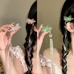 Detail of butterfly hair clip with resin wings, long silk ribbons, and pearl accents