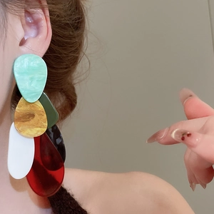 Detail of multi-layered resin teardrop earrings with a vibrant acrylic marble finish