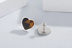 Detail shot of heart-shaped earrings with amber tortoise shell inlay in silver frames