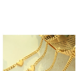 Macro detail of golden Cuban link chain featuring integrated solid heart-shaped charms