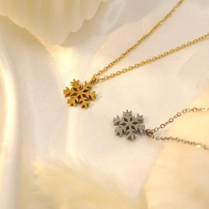 18k gold and silver snowflake pendant necklaces with O-chains on white silk background