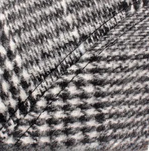 Detail showing precise stitching on black and white wool blend plaid newsboy cap fabric