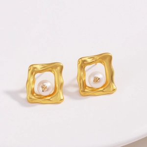 Détail de boucles d'oreilles carrées martelées plaqué or 18 carats avec perle blanche