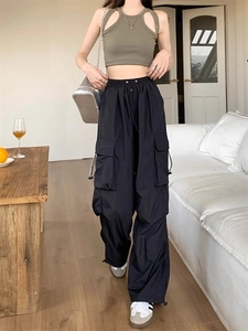 Detail of olive green halter crop top paired with black baggy cargo pants on a model