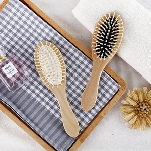 Detailed view of two wooden air cushion massage brushes on a tray with bath accessories