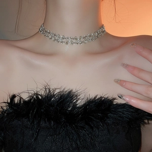 Macro shot of a silver layered diamond necklace on a model wearing black feathers