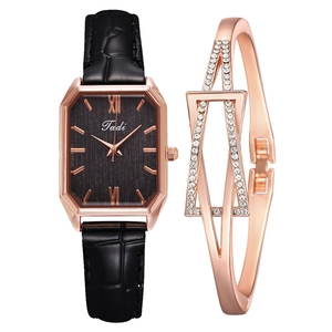 Close-up of vintage square watch with black leather strap and rose gold jewelry set